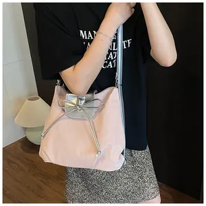 Close-up of pink pleated fabric tote with silver metallic flap and bow detail
