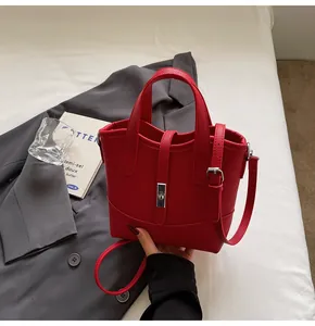 Dettaglio borsa a mano rossa in pelle martellata con fibbia argento e tracolla regolabile