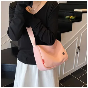Rosafarbene Umhängetasche aus Nylon am Modell zur Veranschaulichung der Größe