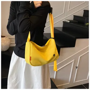 Detail der gelben Nylon-Umhängetasche mit Wabenstruktur und breitem Schultergurt