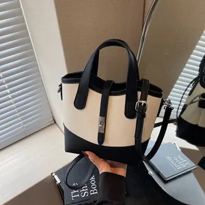 Borsa a secchiello bicolore con trama litchi, chiusura in metallo e tracolla