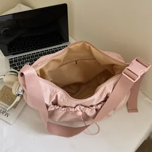 Borsa a tracolla in nylon rosa con ampia tasca interna e dettagli con coulisse