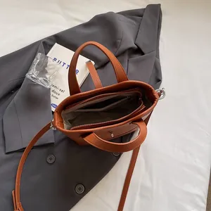 Borsa a secchiello in pelle marrone con manico e tracolla, vista dello spazio interno