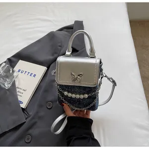 Dettaglio della mini borsa a tracolla con patchwork in pelle argento, denim e perle