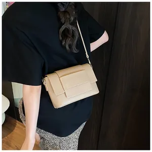 Elegante borsa a tracolla in ecopelle beige mostrata di lato indossata da una modella