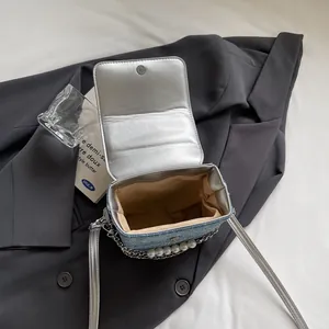 Mini borsa a tracolla in denim azzurro con catena di perle e patta argentata