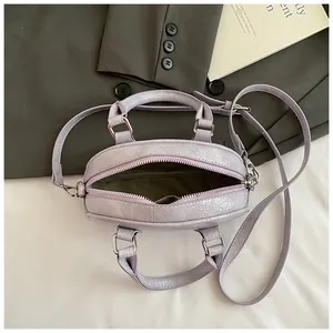 Close-up of light purple textured PU leather bowling bag with twin handles and strap