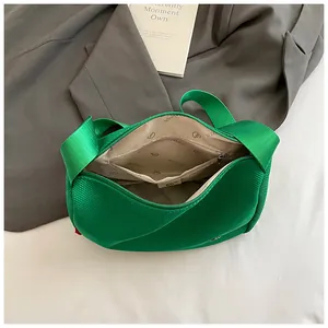 Grüne Nylon-Umhängetasche mit geräumigen Innenfächern und breitem Schultergurt