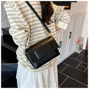 Borsa a tracolla in pelle nera con patta a strati e dettagli metallici color oro