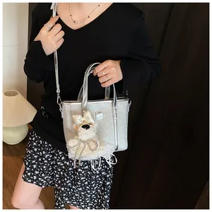 Detail of silver sequin handbag with a cute plush puppy charm and silver shoulder strap