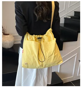 Dettaglio della borsa a secchiello in nylon giallo chiaro con coulisse e ampie tasche
