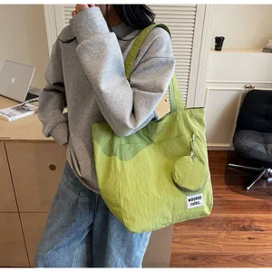 Vue détaillée du grand sac fourre-tout vert nylon avec sa petite pochette assortie