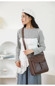 Dettaglio della borsa a tracolla vintage in pelle marrone con fibbia e texture fine
