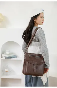 Dettaglio borsa a tracolla vintage in pelle marrone con fibbia e tasca con zip frontale