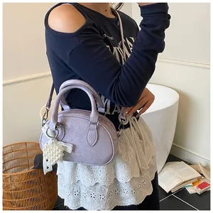 Close-up of lilac bowling bag with pleated texture and pearl heart charm detail