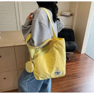 Gros plan du sac cabas jaune avec pochette ronde et étiquette de marque tissée