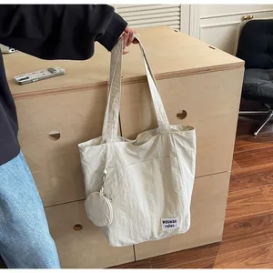 Détail du grand sac cabas blanc cassé avec texture plissée et mini pochette ronde