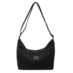Borsa a tracolla nera minimalista a mezzaluna con tracolla regolabile ed etichetta