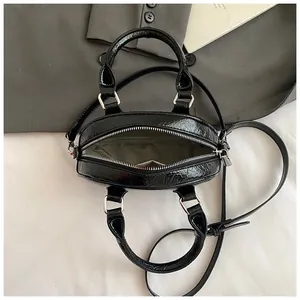 Mini black wrinkled leather bowling bag with dual handles and adjustable shoulder strap