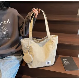 Détail du sac cabas en toile beige avec porte-monnaie rond sur des marches