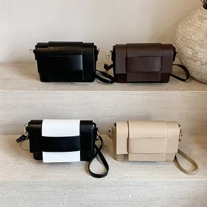 Borse a tracolla minimaliste in ecopelle in quattro colori su un moderno espositore
