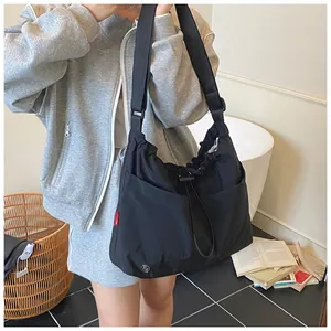 Dettaglio della borsa a tracolla in nylon impermeabile con coulisse e logo rosso