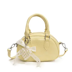 Pale yellow bowling bag with glossy crocodile texture, lace bow, and heart pearl charm