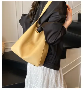 Dettaglio ravvicinato della borsa tote in pelle martellata gialla con logo inciso