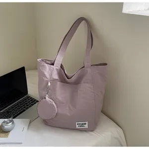 Détail du sac cabas en tissu violet avec poche extérieure et petit porte-monnaie assorti