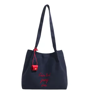 Sac fourre-tout minimaliste en toile bleu marine avec broderie rouge et pendentif en cuir