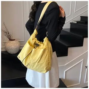 Dettaglio della borsa a secchiello in nylon giallo con coulisse e tasca frontale