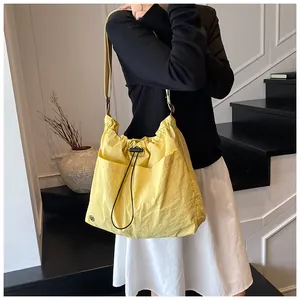 Dettaglio della borsa a secchiello in nylon giallo con grande capacità e tasche laterali
