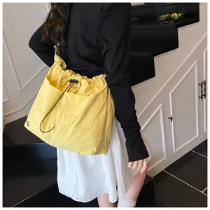 Dettaglio macro borsa a secchiello in nylon giallo impermeabile con coulisse e tasche