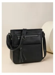 Vista dettagliata della borsa a tracolla vintage nera con cerniere e nappe decorative