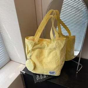 Grand sac fourre-tout jaune minimaliste en nylon texturé avec porte-monnaie rond assorti