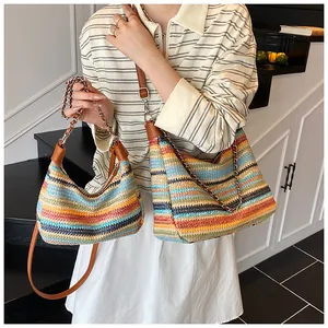 Detail of colorful rainbow woven tote bag with brown leather straps and metal chain