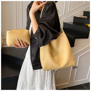 Dettaglio del set borsa tote in pelle gialla a grana con pochette coordinata inclusa