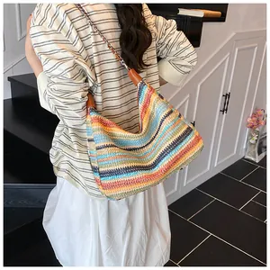 Detail of colorful rainbow straw tote bag featuring chain strap and vibrant woven textures
