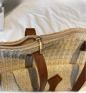 Close-up of smooth gold zipper and beige woven texture on a summer tote bag