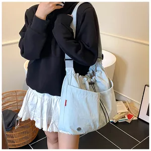 Dettaglio borsa a secchiello in nylon azzurro con chiusura a coulisse e trama pieghettata