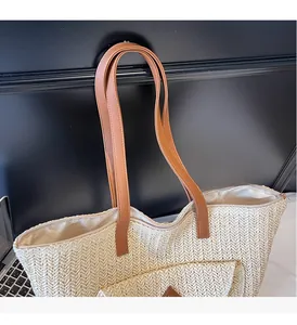 Detail of herringbone straw weave texture and brown leather strap on tote bag