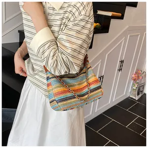 Detail of colorful rainbow woven tote with metallic chain strap and textured straw material