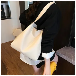 Dettaglio della borsa tote bianco crema con trama in pelle e ampia tracolla comoda