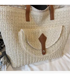 Detail of V-shape woven paper rope bag with brown leather flap and metal buckle closure