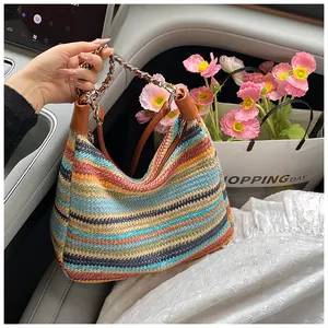 Close-up of rainbow woven tote bag featuring a metal chain strap and leather accents