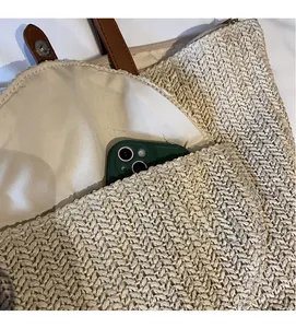 Detail of straw tote bag interior featuring cream fabric lining and practical inner pocket