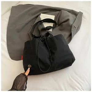 Vista dall'alto di borsa a secchiello in nylon nero impermeabile con chiusura a cordoncino