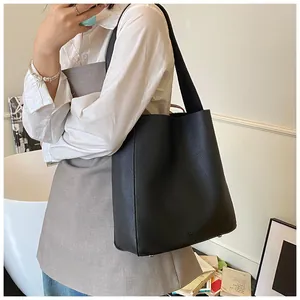 Dettaglio borsa tote in pelle nera con piedini metallici protettivi sulla base