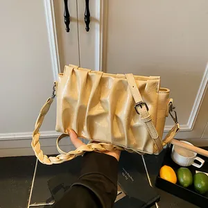 Minimalist pleated cloud bag in pale yellow with dual straps and glossy finish
