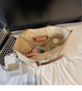 Interior view of the beige straw tote showing large capacity with zipper closure
